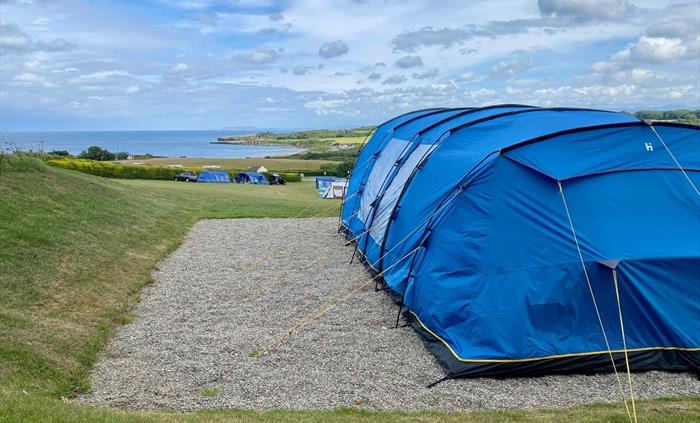 Level all-weather pitches with superb sea views looking over Lligwy Bay towards the Great Orme and Snowdonia.